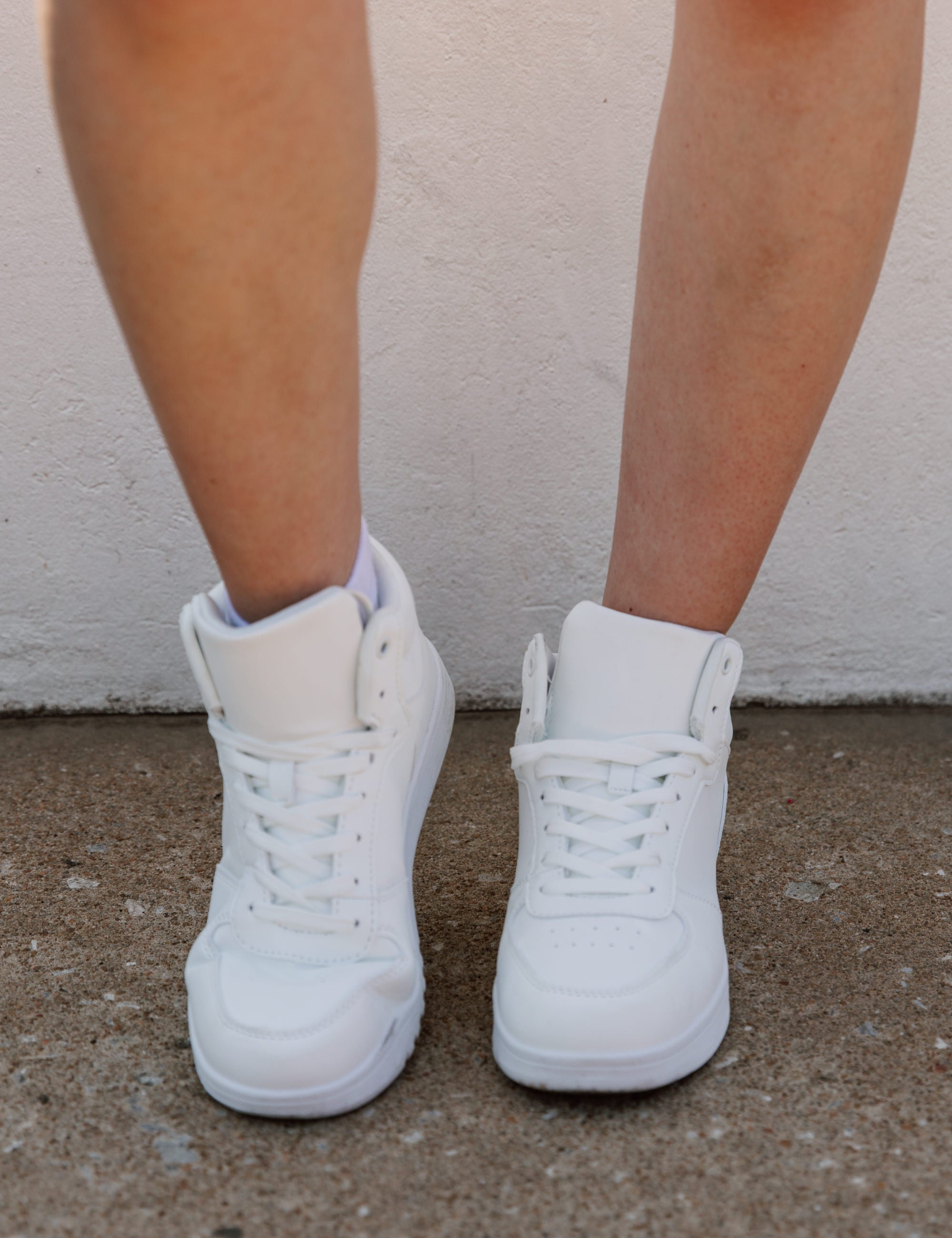 White Step Up Midtop Sneakers - Front View On Model | Gameday Couture - SOHO