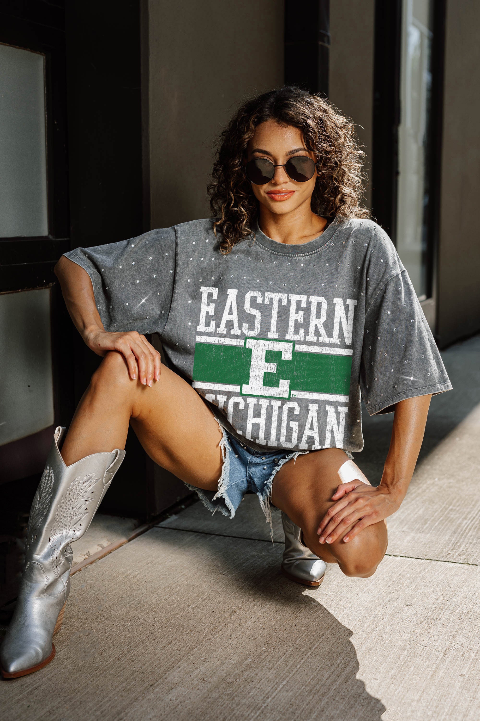 Grey Eastern Michigan Eagles Rhinestone Tee - Seated Lifestyle Shot, Tailgate Gameday Outfit | Gameday Couture - SOHO